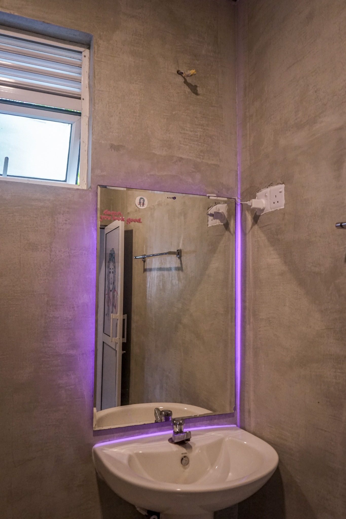 Bathroom sink and mirror with purple accent lighting