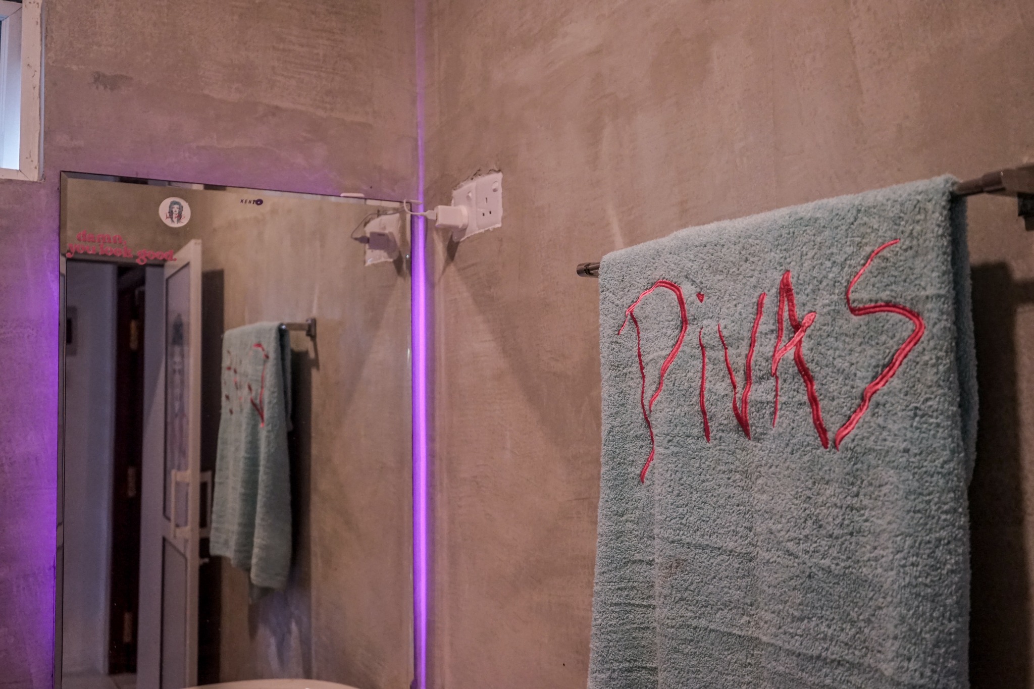 Divas towel hanging beside a bathroom mirror